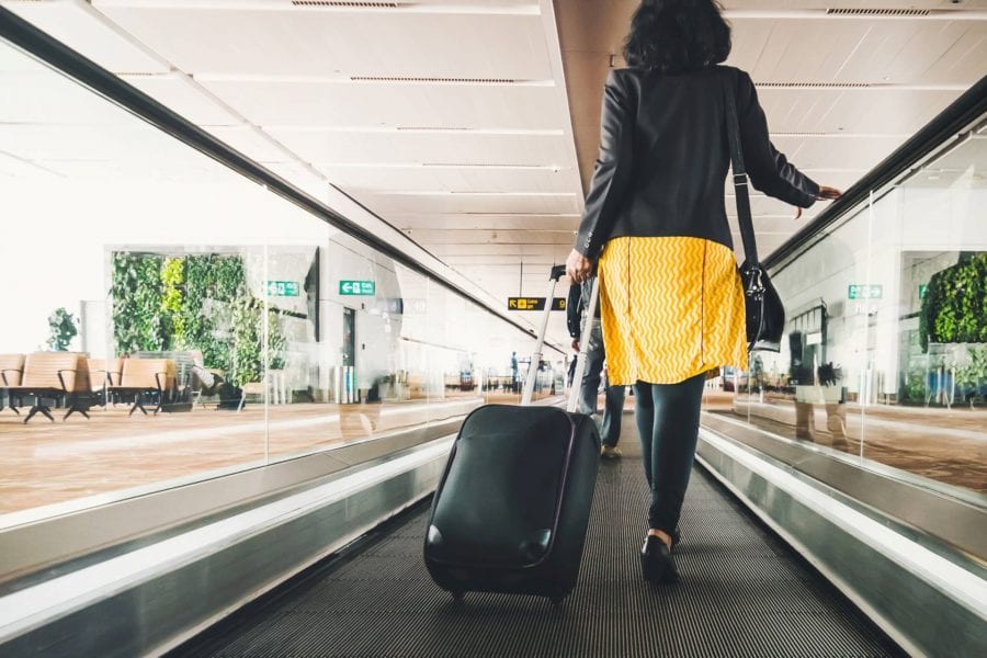 Woman with suitcase on airport walkway