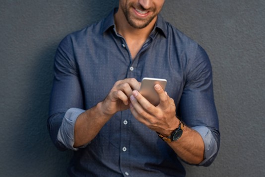 Man smiles while navigating mobile