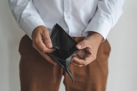 Man holds open empty wallet