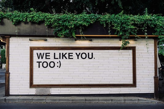 Sign on shop exterior reading “we like you too”